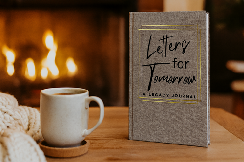 Letters for Tomorrow legacy journal beside a coffee cup by a warm fire, lifestyle setting